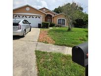 Charming single-story home features an attached garage, well-manicured lawn, and lovely landscaping at 1407 Watermill Cir, Tarpon Springs, FL 34689