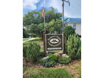 Entrance sign for Belleair Oaks Condominiums at 1975 West Bay Drive beneath an American flag at 1975 W Bay Dr # 304, Largo, FL 33770