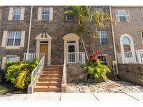 Charming multi-story townhome with brick facade, lush landscaping, and inviting front entrance at 4117 Daventry Ln, Palm Harbor, FL 34685