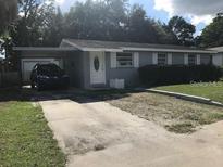 Charming single-story home featuring a carport, well-maintained lawn, and neutral gray paint at 4209 E Hanna Ave, Tampa, FL 33610