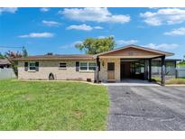 Charming single-story home with brick facade, well-maintained lawn, and covered carport, perfect for comfortable living at 9810 Riverview Dr, Riverview, FL 33578