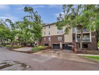 Condo building exterior featuring brick and siding with mature trees and covered parking at 1000 W Horatio St # 129, Tampa, FL 33606