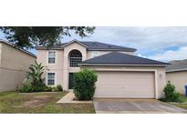Two-story home boasts a lush lawn, landscaped garden, and a two-car garage at 1209 Alhambra Crest Dr, Ruskin, FL 33570