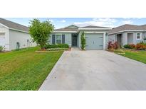 Charming single-Gathering home featuring a well-maintained lawn, driveway, and one-car garage at 17071 Oval Rum Dr, Wimauma, FL 33598