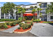 Inviting building exterior showcases lush landscaping and well-maintained grounds, with mature palms and flowering shrubs at 2591 Countryside Blvd # 5304, Clearwater, FL 33761