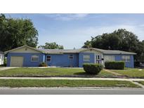 Charming single-story home with a blue facade, well-maintained lawn, and attached garage at 2612 E 17Th Ave, Tampa, FL 33605