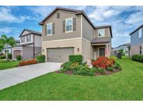 Charming two-story home with well-manicured lawn and colorful flower beds at 6555 Kenava Loop, Palmetto, FL 34221