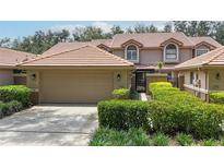 Charming home featuring a tile roof, a well-maintained lawn, and an attached two-car garage at 17544 Fairmeadow Dr, Tampa, FL 33647