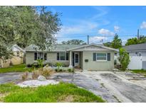 Charming single-story home with a cozy front porch and a well-manicured front yard, set under a sunny blue sky at 1878 New Hampshire Ne Ave, St Petersburg, FL 33703