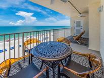 Relax on this balcony with beautiful ocean views, complete with stylish table, seating, and ceiling fan at 20002 Gulf Blvd # 2803, Indian Shores, FL 33785