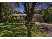 Charming single-story home boasts lush landscaping, mature trees, and a metal roof at 3102 E Trapnell Rd, Plant City, FL 33566