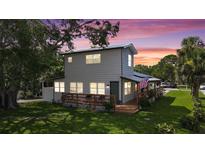 Charming two-story home with a wooden porch and an American flag waving gently in the breeze at 500 62Nd S St, St Petersburg, FL 33707