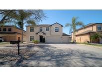 Charming two-story home featuring a three-car garage, neutral color palette, and well-manicured landscaping at 1708 Abbey Trace Dr, Dover, FL 33527
