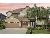 Charming two-story home with a three-car garage, lush landscaping, and a beautiful lawn at 23346 Abercorn Ln, Land O Lakes, FL 34639