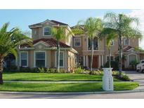 Stately two-story home with a red tile roof, lush lawn, and manicured landscaping at 10549 Cory Lake Dr, Tampa, FL 33647