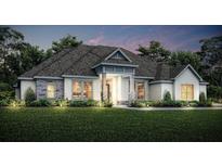 Charming single-Gathering home boasts a symmetrical facade, and a covered front porch set amidst a lush lawn at 13570 Saddlebred Ln, Hudson, FL 34667