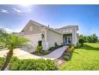 Charming single-story home featuring a two-car garage, landscaping, and a welcoming front porch at 13621 Circa Crossing Dr, Lithia, FL 33547
