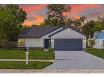 Charming single-story home with a well-manicured lawn and a two-car garage at sunset at 2908 Longbrooke Way, Clearwater, FL 33760