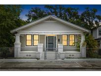 Charming single-story home featuring a fenced yard, symmetrical columns, and a cozy front porch at 3105 N 16Th St, Tampa, FL 33605