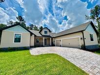 Charming single-story home with a spacious paved driveway and a manicured lawn at 4800 Hickory Oak Dr, Brooksville, FL 34601