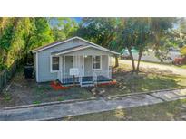 Charming cottage-style home featuring a cozy front porch and fresh landscaping at 2101 E Ellicott St, Tampa, FL 33610