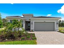 Charming single-story home featuring a two-car garage, paved driveway, and professionally landscaped front yard at 6982 Minneola Ct, Nokomis, FL 34275