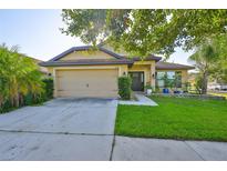 Charming single-story home featuring an attached two-car garage and well-manicured front lawn at 12218 Avondale Oak Pl, Riverview, FL 33578