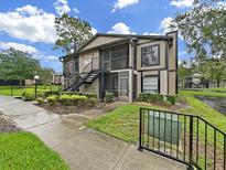 Two-story condo building with mature landscaping and visible stairs at 3964 Dream Oak Pl # 203, Tampa, FL 33613