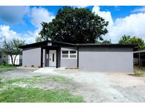 Charming single-story home with a gray exterior, fresh landscaping, and a well-manicured front yard at 4720 Murray Hill Dr, Tampa, FL 33615