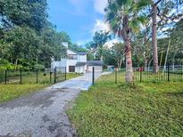 Charming two-story home with black iron fence, lush landscaping, and a long drive at 10928 Echo Loop, New Port Richey, FL 34654