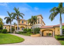 Grand two-story home with a large driveway and lush landscaping at 1363 Oceanview Dr, Tierra Verde, FL 33715