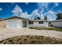 Single story home with white brick exterior and attached garage at 3423 Eisenhower Dr, Holiday, FL 34691