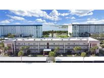 Aerial view of a waterfront community with multiple buildings and parking at 8 Glencoe Pl # 208, Dunedin, FL 34698