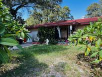 House with red tile roof and landscaped yard at 1942 Alton Dr, Clearwater, FL 33763