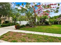 House with blooming tree and landscaped yard at 4931 Ridgemoor Cir, Palm Harbor, FL 34685