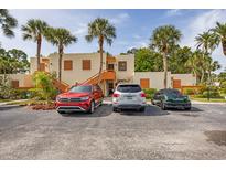 Condo building exterior with parking and tropical landscaping at 220 Pineneedle Dr # 220, Bradenton, FL 34210