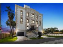 An elegant exterior view of a multi-story home, featuring dual garages and a meticulously landscaped front yard at 3087, 3075 Cherry Ln, Clearwater, FL 33759