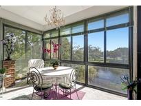 Bright sunroom features a table for dining and scenic lake views at 14130 Rosemary Ln # 3309, Largo, FL 33774