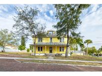 Large yellow house with a porch and brick driveway at 553 Division St, Tarpon Springs, FL 34689