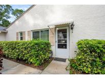Condo exterior showcasing a walkway, hedges and white walls at 3348 38Th S Way # C, St Petersburg, FL 33711