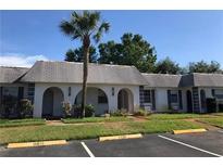 Two-story building with grey roof and palm tree at 4242 Redcliff Pl # 4242, New Port Richey, FL 34652