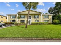 Two-story building with green lawn and palm tree in front at 1001 Eden Isle Ne Dr # 1, St Petersburg, FL 33704