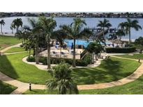 A beautiful pool area with a large pool, lounge chairs, and palm trees, perfect for relaxation at 5130 Brittany S Dr # 408, St Petersburg, FL 33715