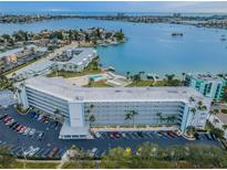 Stunning aerial view of the waterfront condo building with a pool and boat access at 1868 Shore S Dr # 410, South Pasadena, FL 33707