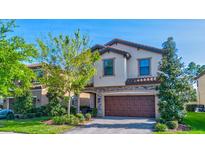 Two-story home with a two-car garage and landscaping at 12874 Burns Dr, Odessa, FL 33556
