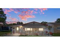 Single-story house with awning and white fence at 247 93Rd N Ave, St Petersburg, FL 33702