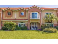 Charming townhome featuring a balcony, a patio area with seating, and lush green landscaping at 6251 Vista Verde W Dr, St Petersburg, FL 33707
