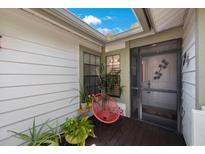 Inviting front entry with red chair and plants at 842 Amelia Ne Ct, St Petersburg, FL 33702