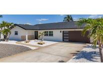 Beautiful single-story home featuring a modern garage door, well-maintained driveway, and manicured landscaping at 240 N Julia Cir, St Pete Beach, FL 33706