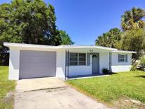 Updated Ranch home exterior with gray garage door and well-manicured lawn at 6639 Sandra Dr, Port Richey, FL 34668